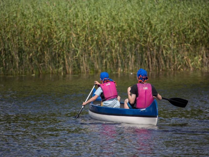 2 Pfadfinder auf einem Fluss im Ruderboot