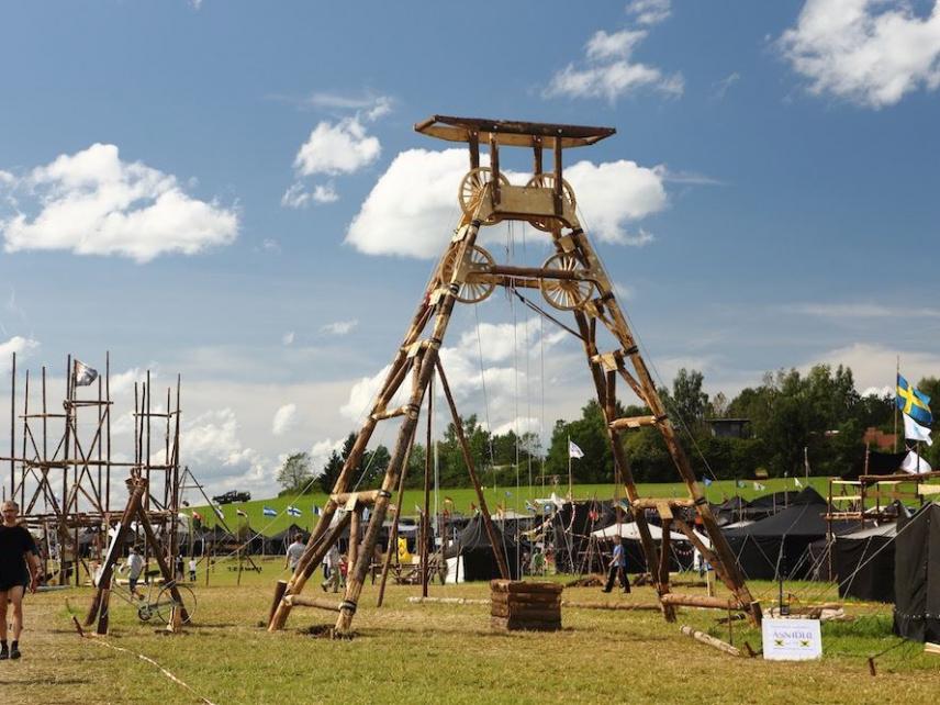 Pfadfinder  bauen neben einem Hochstand eine Hütte